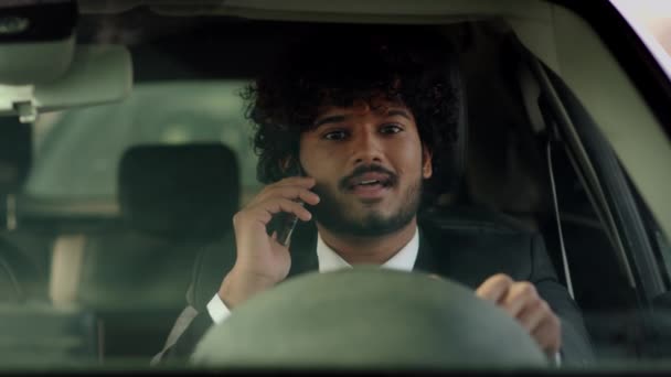 一个满头卷发的男人坐在车轮子后面 在电话里聊天 站在交通堵塞的情况下 微笑着在电话上交谈的男性商人 高质量的4K镜头 — 图库视频影像
