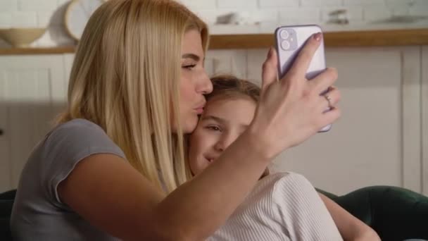 Sonriente Madre Besa Hija Mientras Toma Selfie Mamá Joven Está — Vídeos de Stock