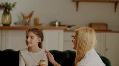 Annem, kızının doğum günü şerefine elinde mumla neşeli bir kek getirdi. Gülümseyen kız ve doğum günü şerefine bir sürpriz. Yüksek kalite 4k görüntü