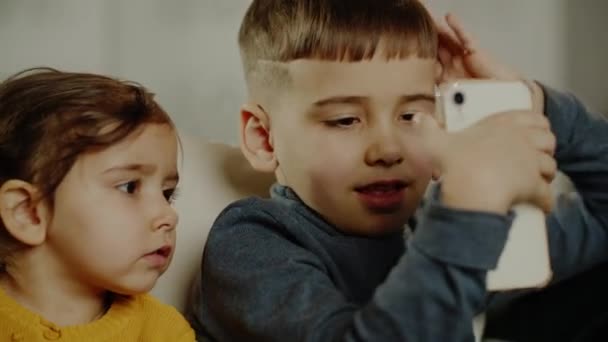 Liten Pojke Och Flicka Använder Smartphone För Underhållning Utan Föräldrarnas — Stockvideo