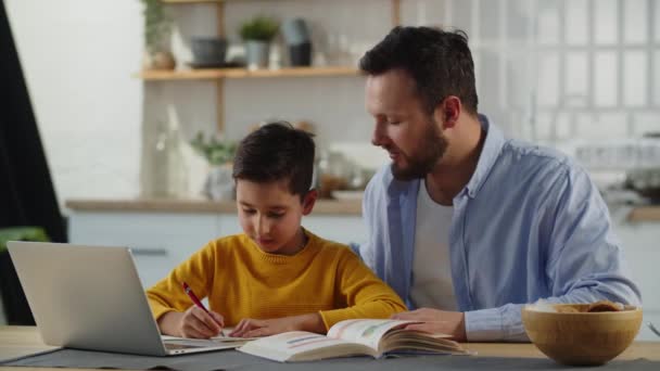 Pečující Otec Pomáhá Svému Synovi Domácím Úkolem Chlapec Sedí Stolu — Stock video