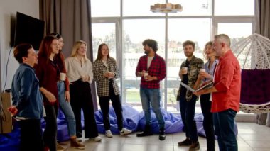 Ofis çalışanları dinlenme odasında durup bir şey tartışıyorlar. İş arkadaşları sohbet eder ve öğle arasında fincanlardan kahve içerler. Yüksek kalite 4k görüntü