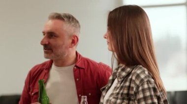 Ofis çalışanları meslektaşlarının doğum günü onuruna küçük bir parti düzenlediler. İnsanlar ofisin ortasında ellerinde alkollü içkilerle durup bir şeyler tartışıyorlar. Yüksek kalite 4k görüntü