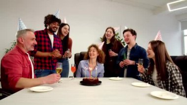 Genç kızıl saçlı kadın iş arkadaşlarıyla birlikte ofiste doğum gününü kutluyor. Ofis çalışanları meslektaşlarını doğum günü için kutluyor ve ona bir şarkı söylüyorlar. Yüksek kalite 4k görüntü