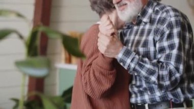 Son sınıf çifti mutfakta birlikte dans ederken gülümsüyor. Geri çekilme, emeklilik ve mutlu son sınıf yaşam tarzı konsepti. Yüksek kalite 4k görüntü