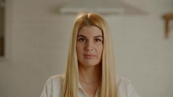 Młoda Blondynka Surowo Spojrzy Prosto Kamerę Poważna Dziewczyna Białej Koszuli — Wideo stockowe