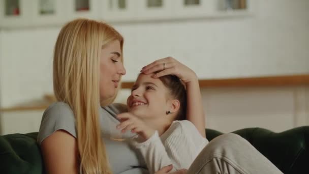幼い母親と成長する娘は自宅のソファに優しく抱きつく 母親の優しさと愛の症状 高品質4K映像 — ストック動画