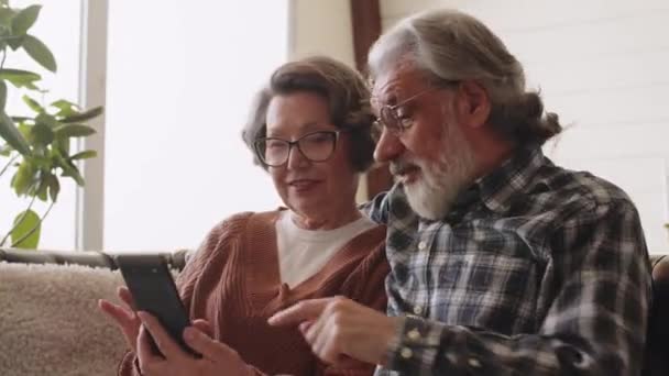 Szczęśliwa Starsza Para Trzymająca Smartfona Patrząca Ekran Telefonu Komórkowego Kobieta — Wideo stockowe