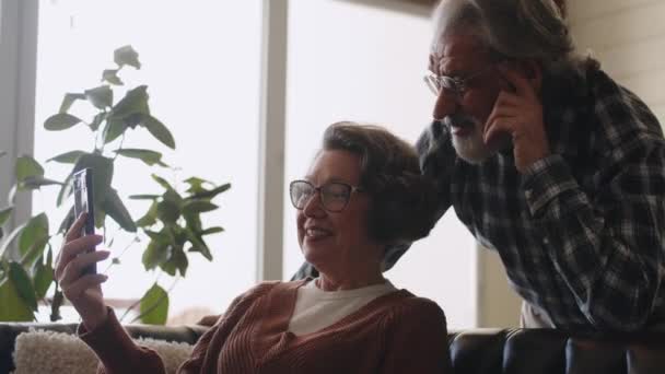Glada Äldre Par Som Använder Smarta Telefoner Tillsammans Ett Leende — Stockvideo