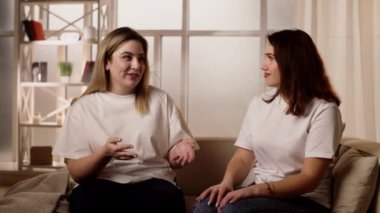Neşeli genç iki kadın birlikte konuşuyor. Kızlar dedikodu yapar, heyecan verici hayat hikayelerini paylaşır. Yüksek kalite 4k görüntü