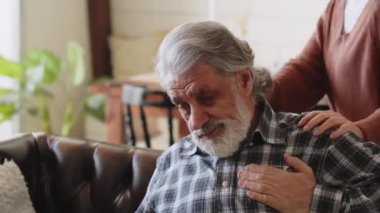 Yaşlı adamın göğüs ağrısı var. Evde göğüs ağrısı çeken olgun bir adam. Kalp sorunu olan insanlar kavramı. Yüksek kalite 4k görüntü