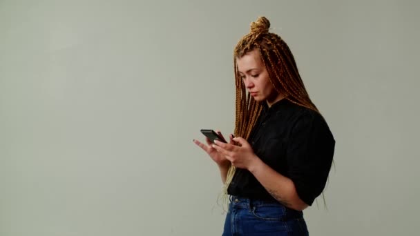 Egy Fiatal Lány Divatos Frizurával Érzelmileg Reagál Egy Üzenetre Telefonján — Stock videók