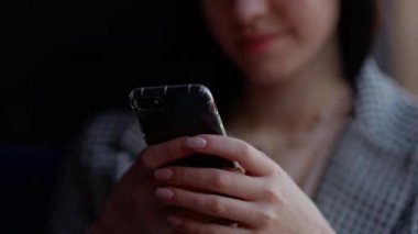 Genç ve çekici bir kız bir nakliye aracında oturuyor ve telefondaki yazışmalara tatlı tatlı gülüyor. Yüksek kalite 4k görüntü