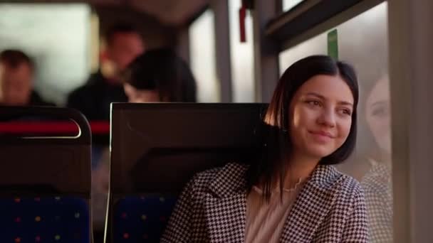 사려깊은 소녀가 대중교통을 이용합니다 소녀는 창밖을 내다보며 상냥하게 미소를 지었다 — 비디오