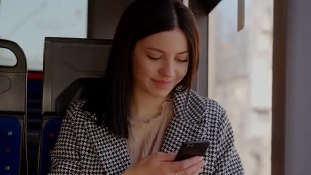年轻的女乘客在乘坐现代公共交通时 在智能手机上输入信息 享受乘坐公共交通的乐趣 高质量的4K镜头 — 图库视频影像