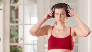 Kırmızı spor kıyafetli bir kadın kulaklık takar ve sabah sporuna başlar. Genç bir esmer, sabah egzersizi sırasında kulaklıkla müzik dinler. Kadın omuzlarını ve boynunu ovuyor. Yüksek