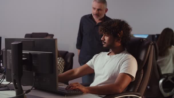 Młody Człowiek Pracujący Firmie Informatycznej Pisze Coś Klawiaturze Siedząc Biurze — Wideo stockowe