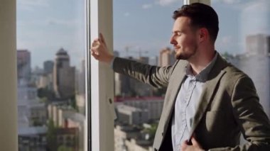 Man sitting on the roof of a big building and look at the city. Concept of big money, success, when dreams comes true. High quality 4k footage