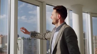 Man sitting on the roof of a big building and look at the city. Concept of big money, success, when dreams comes true. High quality 4k footage