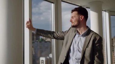 Man sitting on the roof of a big building and look at the city. Concept of big money, success, when dreams comes true. High quality 4k footage