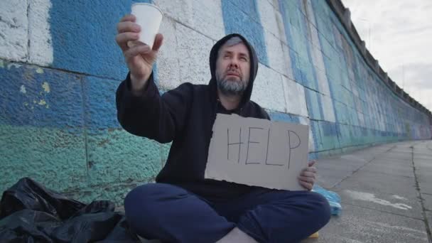 Бездомный Бедный Молодой Человек Сидящий Земле Городе Столом Помощи Прося — стоковое видео
