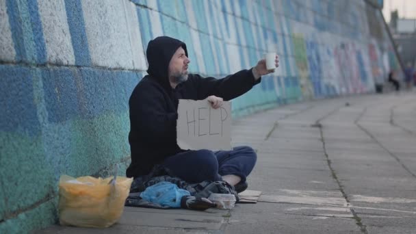 Hajléktalan Szegény Fiatalember Földön Városban Egy Segítő Asztal Miközben Pénzt — Stock videók