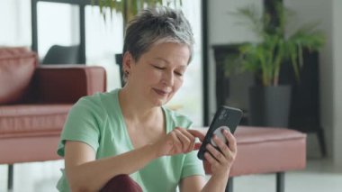 Yaşlı kadın evde yoga egzersizi yapıyor. Olgun kadınlar meditasyon yapar. Yüksek kalite 4k görüntü