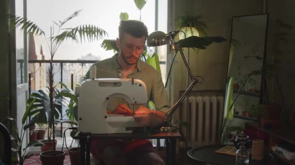 男装设计师在家里的缝纫机上工作 年轻的企业家开始在家里的大绿色工厂的房间里做缝纫生意 手工和制造的概念 高质量4K — 图库视频影像