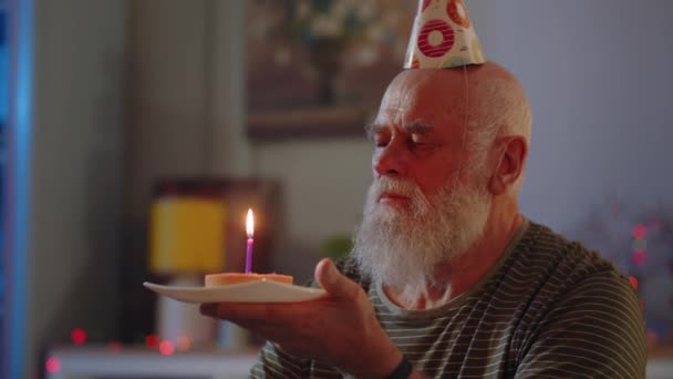 一个老人一个人在家庆祝他的生日 每个人都忘了生日 一位年迈的病人看着蛋糕 许了个愿 吹灭了蜡烛 高质量的4K镜头 — 图库视频影像