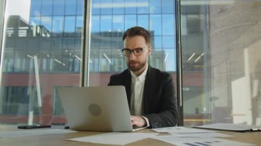 Gözlük takan, gözlüklü, bilgisayar ekranına bakan, gözlüğe yansıyan ve online ticaret piyasasının dijital verilerini analiz eden olgun bir iş adamı. Görüntüyü kapat