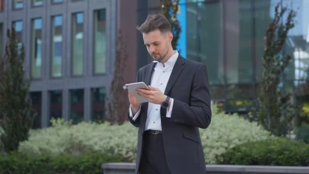휴대폰읽기 이메일을 거리에 세련되고 잘생긴 사업가가 스마트폰으로 모바일 사용하여 온라인 — 비디오