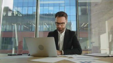 Bilgisayar ekranına bakarak online ticaret piyasasının dijital verilerini analiz eden olgunlaşmış bir işadamı. Gözlüklerini tak ve dizüstü bilgisayara bak. Yüksek kalite 4k