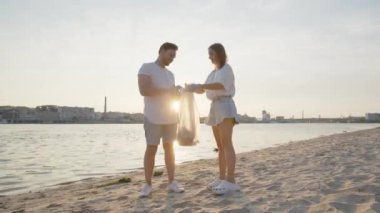 Bir grup çevreci doğadaki çöpleri temizliyor. Doğada plastik bir torba içinde çöp toplayan gençlerin yakın çekimi. Yeşil yaşam ve ekoloji kavramı. Yüksek kalite 4k görüntü