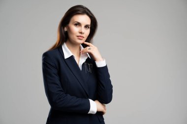 Genç ve zeki pazarlama asistanı kadın çalışan kadın ciddi bir yüz ifadesiyle çeneye dokunuyor. Resmi kıyafet sekreteri, genç kız. Yüksek kalite fotoğraf