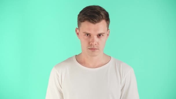 Ung Man Vit Shirt Poserar Studion Blå Bakgrund Killen Visar — Stockvideo
