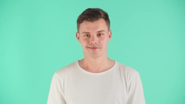 티셔츠를 남자가 파란색 배경에 스튜디오에서 자신감있는 모습과 얼굴에 아름다운 미소를 — 비디오