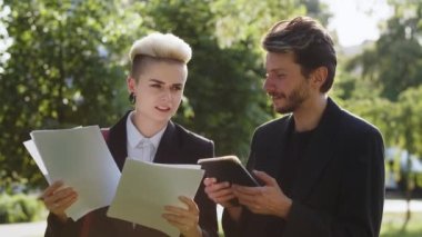 Kendine güvenen iki iş adamı projeyi tamamladı. Genç bayan ve patron arasındaki tartışma bahçedeki istatistikleri açıklıyor. Meslektaşlar parkta yürürler. Yüksek kalite 4k görüntü