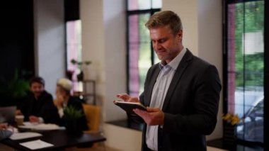 Kendine güvenen veri analizleri yeni ekip üyesi cihazları kontrol ediyor. İş adamı bilgi araştırması için tablet kullanıyor. Başarılı girişimci takım oluşturma geçmişindeki e-postaları kontrol eder. Yüksek kalite 4k