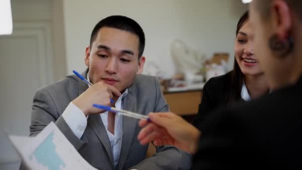 Впевнений Молодий Китайський Бізнесмен Зосередився Вступних Діаграмах Паперів Три Бізнесмени — стокове відео