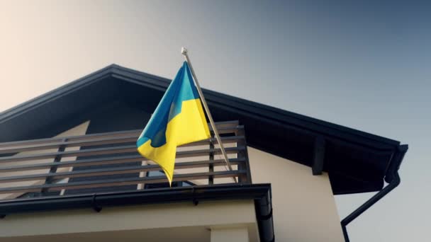 乌克兰的国家黄色蓝色旗帜飘扬在一座私人住宅之上 乌克兰房地产和住房的广告 购买和销售 晴朗的夏天 头顶上和平的天空 高质量4K — 图库视频影像