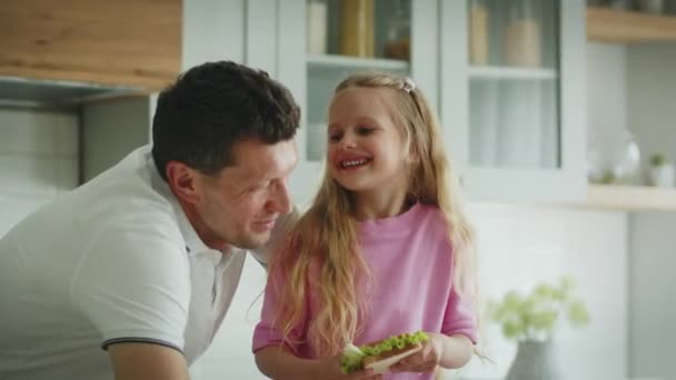 Glad Smilende Lille Pige Med Sandwich Hænderne Står Køkkenet Ved – Stock-video