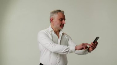 Orta yaşlı bir adam akıllı telefon kullanır, göz yorgunluğu, görme bozukluğu ya da hipermetrop yüzünden onu uzaklaştırır. Bir işadamı ya da patron bir ortakla sohbet eder ya da mesajlaşır ya da ona bağlı olarak emir verir. Şey...