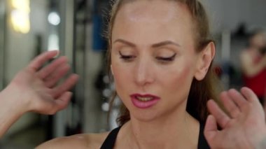 Spor salonundaki genç bir bayan sporcu karın kaslarını konsantrasyonla pompalıyor. Güzel gözlü çekici bir sporcu kadın poz verir ve kameraya bakar. Yavaş çekim videosu. Kapatın. Yüksek kalite 4k görüntü