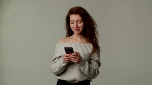 Atrakcyjna Uśmiechnięta Dziewczyna Używa Smartfona Przesyła Wiadomości Swojemu Chłopakowi Młoda — Wideo stockowe