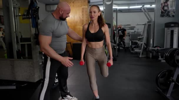 Leende Kvinna Gör Fysiska Övningar Gymmet Överinseende Mannen Fitness Instruktör — Stockvideo