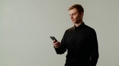 Ciddi görünümlü bir öğrenci, yorgunluğu ve iyi görüşü korumak için emailleri gözlerinden uzak tutmak için akıllı telefon kullanır. Genç bir patron bir ortakla iş yazışmaları yapar.