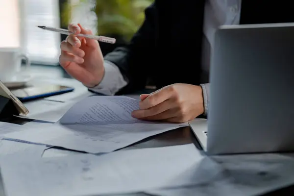 Ofiste kurşun kalemle not alan el kameralarını kapatın. İş adamı kolu detayları kontrol ettikten sonra kontrat imzalıyor. İş kadını, dizüstü bilgisayarın yanında imza atma anlaşması yapıyor. Yüksek kalite fotoğraf