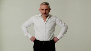 Orta yaşlı bir patron katil bakışlarına kızar. Astlarını azarlamaya hazır. Agresif duruşu olan ve öfke duyan bir işadamı kayboluş nedenlerinin açıklanmasını bekler.