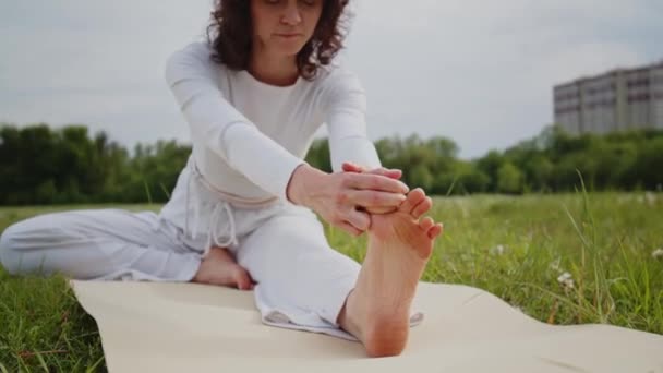 Жінка Тягнеться Торкається Ноги Йоги Парку Дівчина Білому Спортивному Одязі — стокове відео