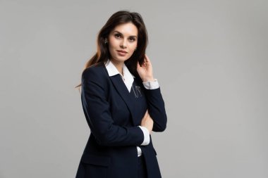 Resmi kıyafet giyen genç bir iş kadını. İş kadını esmer saçlarına dokunuyor. Harika bir CEO yöneticisi. Zeki kadın cazibesi poz veriyor. Güzel bayan işveren. Yüksek kalite fotoğraf